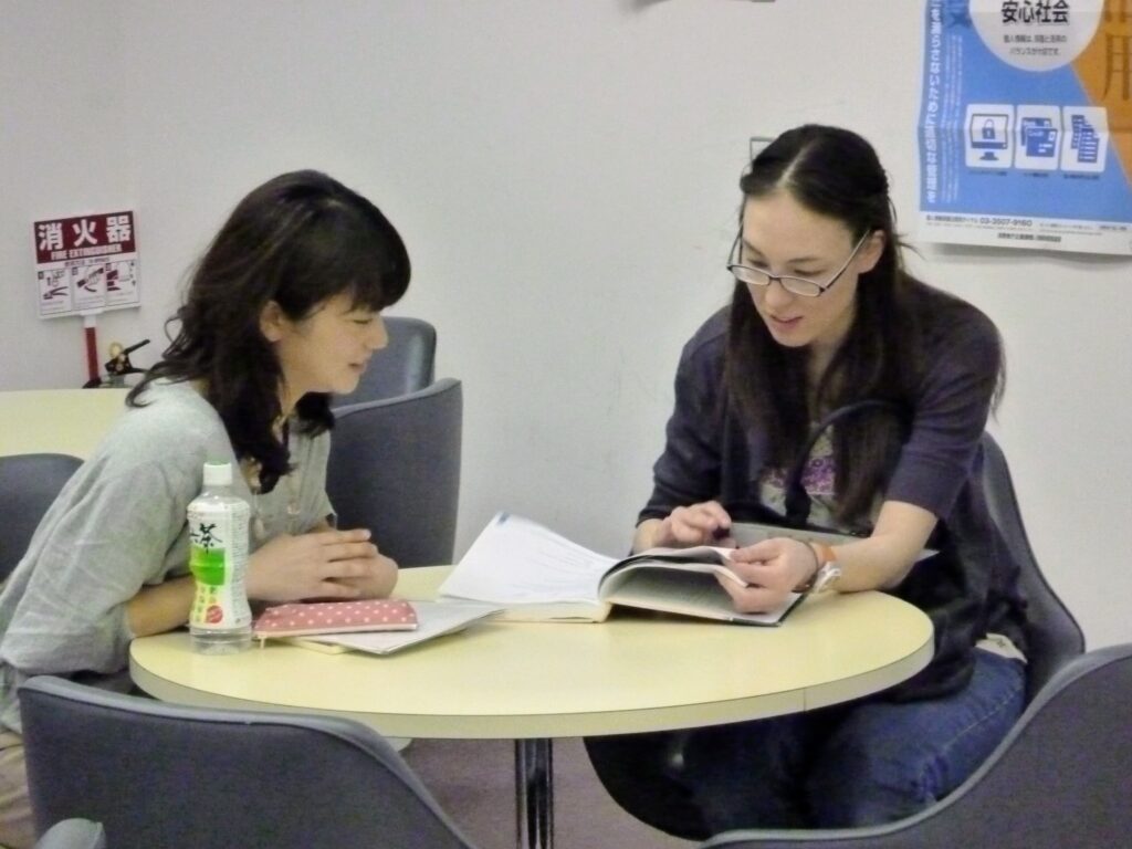 日本語講師と学習者が教材を使って個別レッスンを行う様子